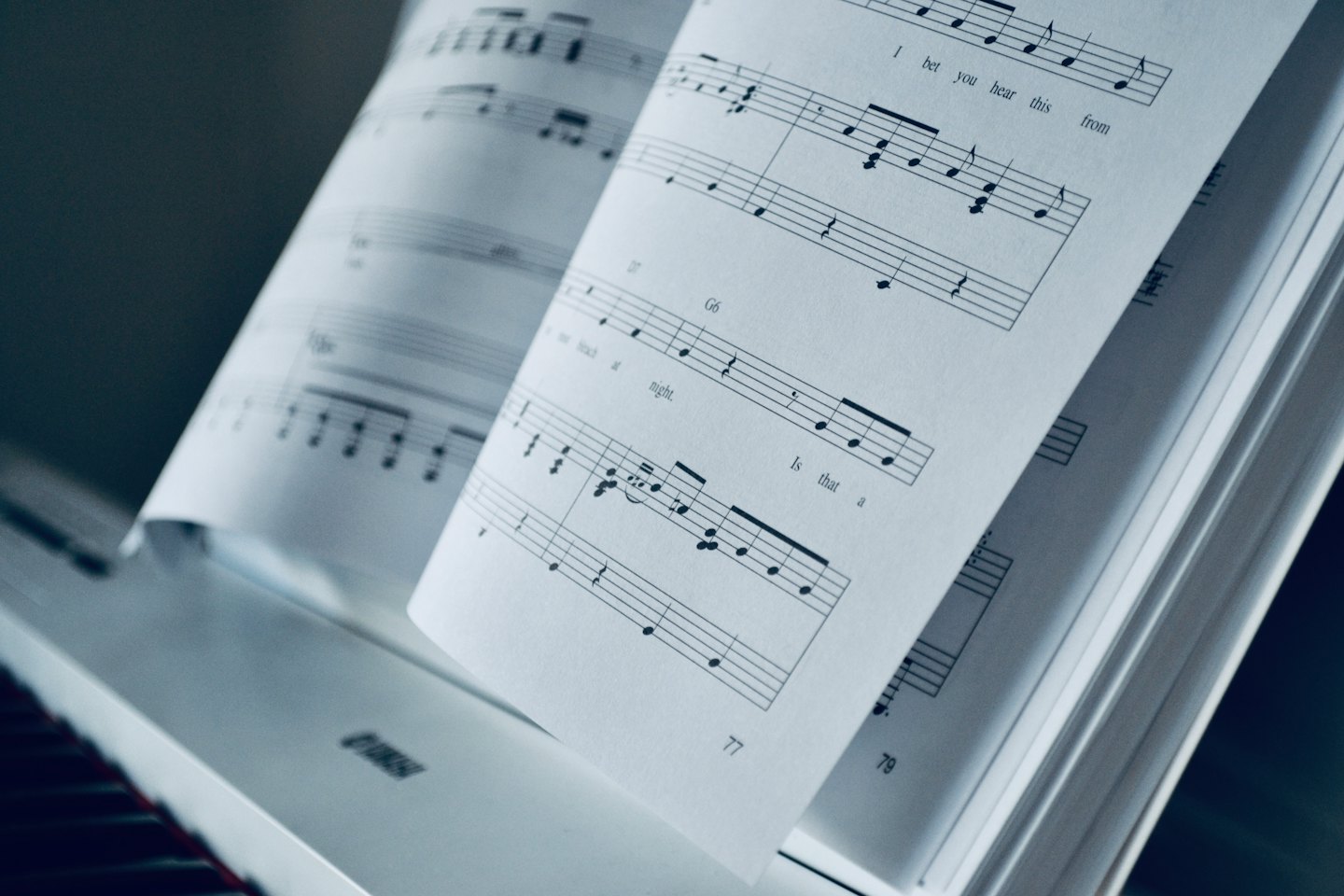 An open music book with notes and lyrics on a stand.